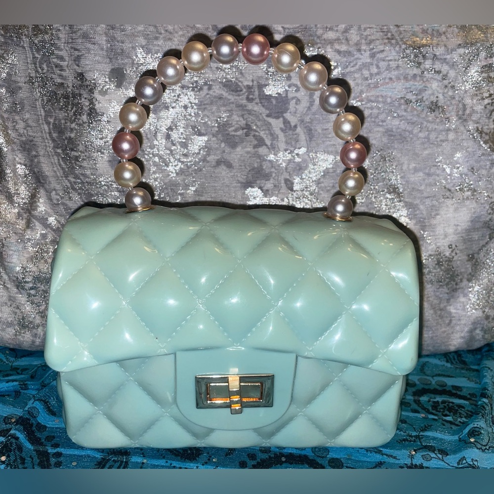 Pastel green quilted bag with pearl handle.
